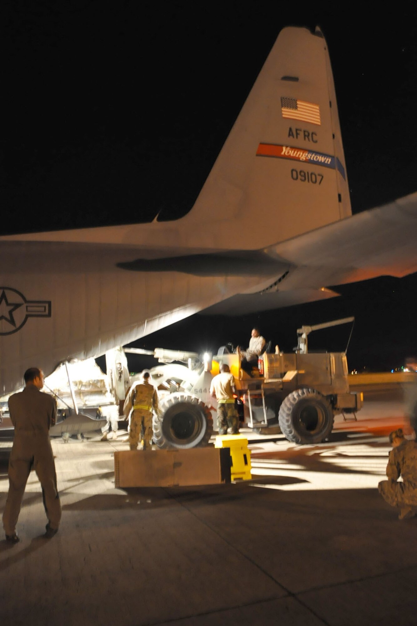 SOTO CANO AIR BASE, Honduras -- Air Force Reserve Maj. Joe George, assigned to the 910th Operations Support Squadron, observes as ground cargo handling personnel use a forklift to load a pallet load aboard a C-130H Hercules tactical cargo transport aircraft, assigned to the 910th Airlift Wing, on the cargo ramp here, January 17. Maj. George is pilot of the C-130H and commander of a 12-person crew from the 910th, based at Youngstown Air Reserve Station, Ohio, scheduled to deliver the pallet, a HUMVEE military vehicle, a trailer and supplies along with a group of U.S. Military medical personnel to Port-au-Prince International Airport, Haiti as part of the relief effort to aid the people of the stricken island nation in the aftermath of the massive earthquake that devastated Port-au-Prince and surrounding areas last week. The 910th currently has three aircraft, crews of more than 30 personnel flying relief effort missions and a myriad of Citizen Airmen working at YARS to provide home station support to the crews. The 910th Airlift Wing stands ready to provide airlift capabilities to the massive humanitarian effort as long as needed by mission requirements. 