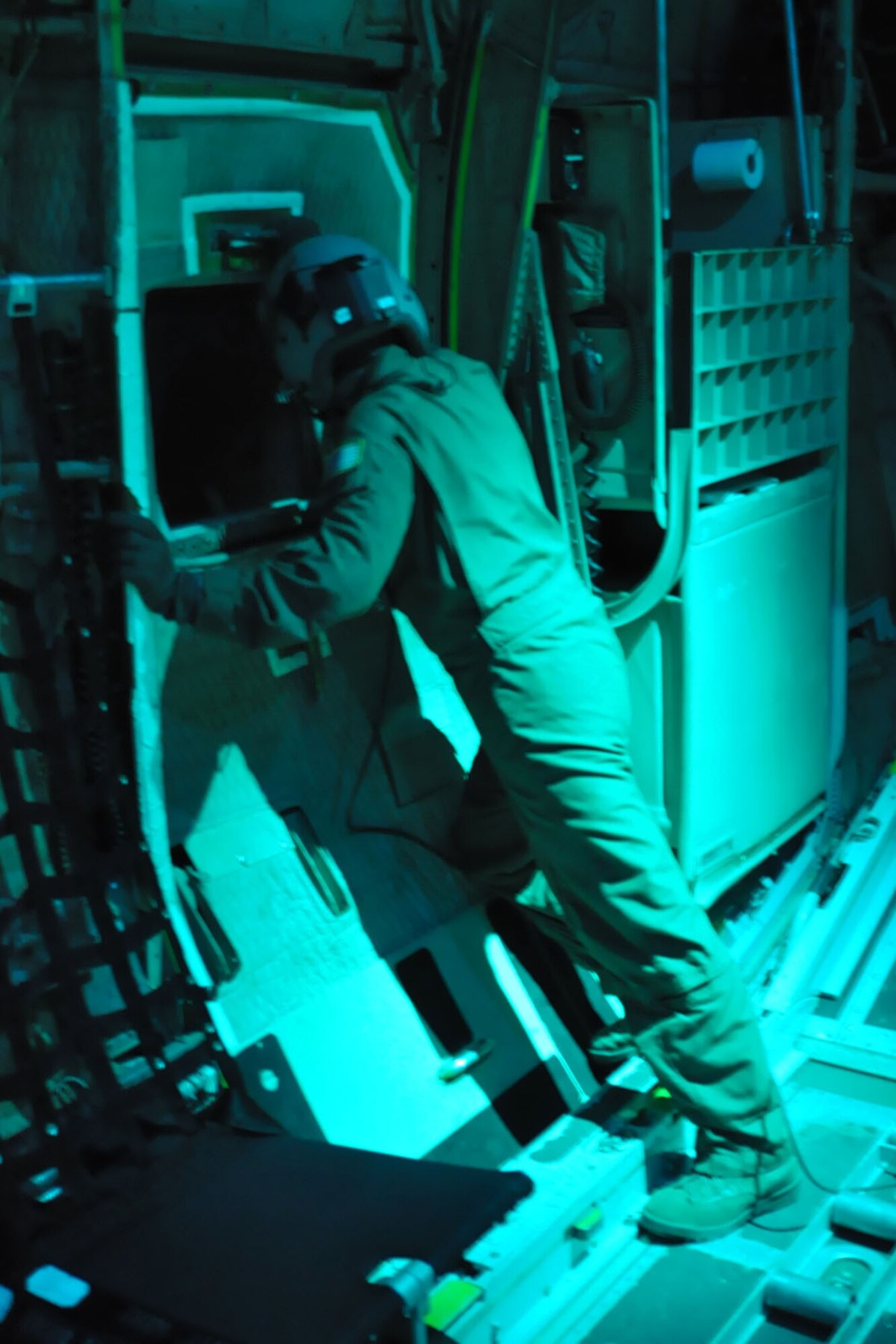 SOMEHWERE OVER HONDURAS -- Air Force Reserve Staff Sgt. Michael Culp, a loadmaster assigned to the 773rd Airlift Squadron, uses Night Vision Goggles (NVGs) as he looks out the crew door of a C-130H Hercules tactical cargo transport aircraft on an airlift mission, January 17, in support of relief efforts in the aftermath of an earthquake that devastated Port-au-Prince, the capital of Haiti. Sergeant Culp is among a 12-person crew aboard the C-130H assigned to the 910th Airlift Wing, based out of Youngstown Air Reserve Station, Ohio, bound for Soto Cano Air Base, Honduras to pick up cargo in support of the massive international effort to aid the people of the stricken island nation. He is aiding the flight crew as they prepare to land using NVGs at the air base in Honduras. The 910th currently has three aircraft, crews of more than 30 personnel flying relief effort missions and a myriad of Citizen Airmen working at YARS to provide home station support to the crews. The 910th Airlift Wing stands ready to provide airlift capabilities to the massive humanitarian effort as long as needed by mission requirements.