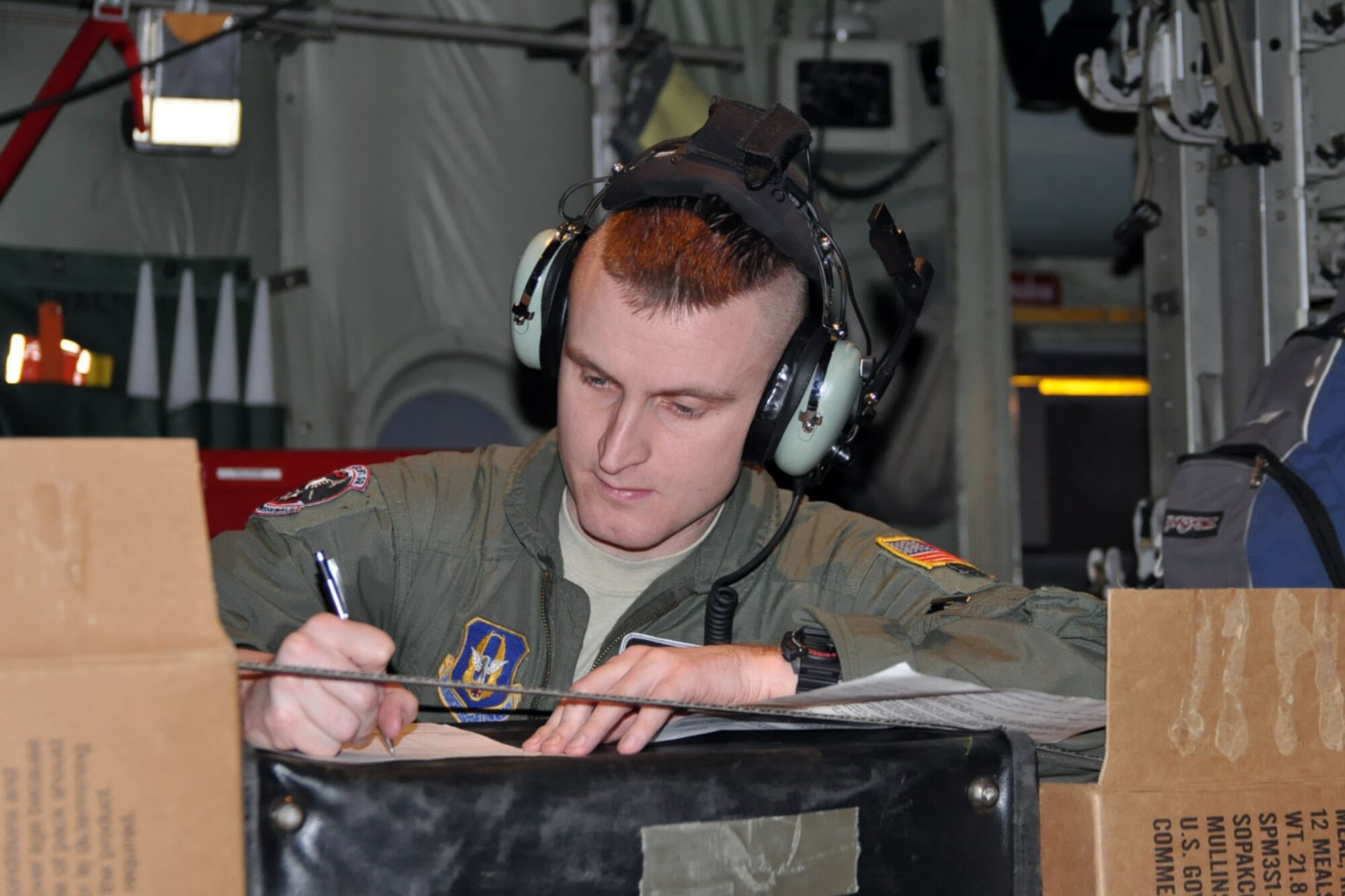SOMEHWERE OVER THE CARIBBEAN SEA -- Air Force Reserve Staff Sgt. Michael Culp, a loadmaster assigned to the 773rd Airlift Squadron, fills out customs declaration forms as part of his duties aboard a C-130H Hercules tactical cargo transport aircraft on an airlift mission, January 17, in support of relief efforts in the aftermath of an earthquake that devastated Port-au-Prince, the capital of Haiti. Sergeant Culp, one of two loadmasters responsible for payload on the aircraft, is among a 12-person crew, assigned to the 910th Airlift Wing, based out of Youngstown Air Reserve Station, Ohio, bound for Soto Cano Air Base, Honduras to pick up cargo in support of the massive international effort to aid the people of the stricken island nation. The 910th currently has three aircraft, crews of more than 30 personnel flying relief effort missions and a myriad of Citizen Airmen working at YARS to provide home station support to the crews. The 910th Airlift Wing stands ready to provide airlift capabilities to the massive humanitarian effort as long as needed by mission requirements.
