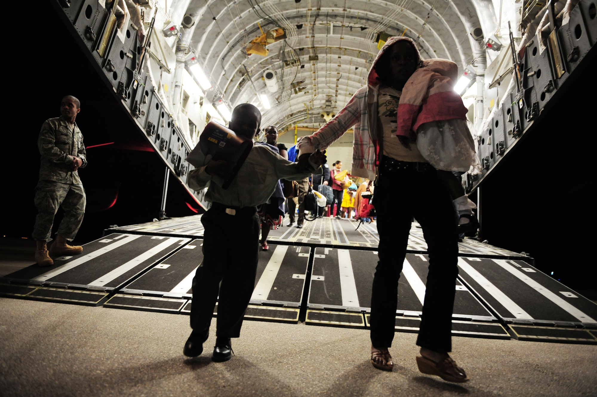 Haitian-American evacuees exit a C-17 Globemaster III Jan. 18, 2010, at Orlando Sanford International Airport, Fla. The C-17 crew is assigned to the 729th Airlift Squadron at March Air Reserve Base, Calif. The aircraft is from the 452nd Air Mobility Wing at March ARB. (U.S. Air Force photo/Staff Sgt. Jacob N. Bailey)