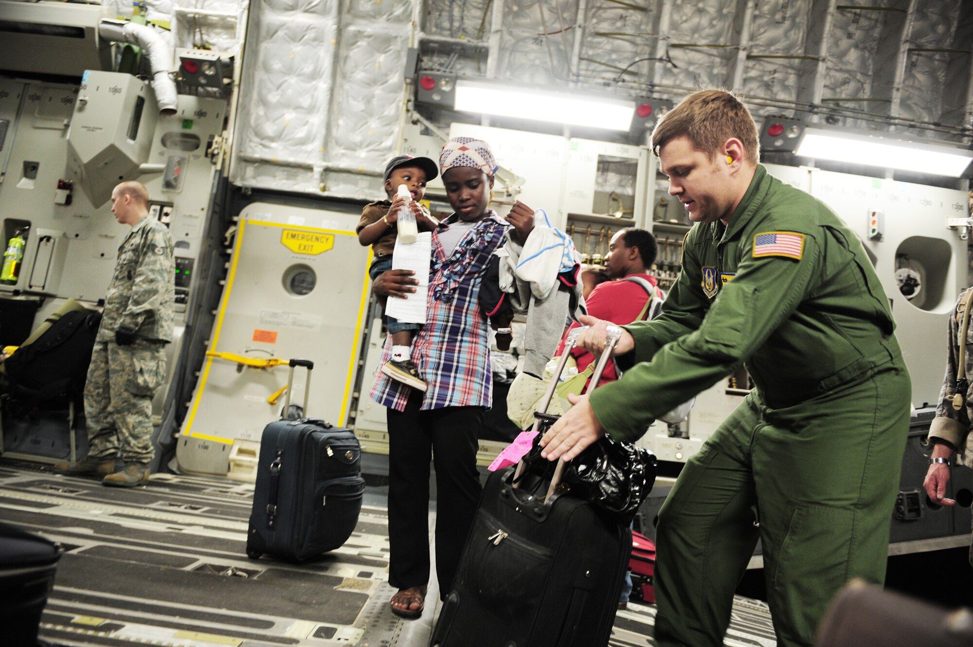 Tech Sgt. Andrew Lucas (left) assists Haitian-Americans Jan. 18, 2010 at Toussaint L'Ouverture International Airport in Port-au-Prince, Haiti. Sergeant Lucas is a loadmaster assigned to the 729th Airlift Squadron at March Air Reserve Base, Calif. (U.S. Air Force photo/Staff Sgt. Jacob N. Bailey) 