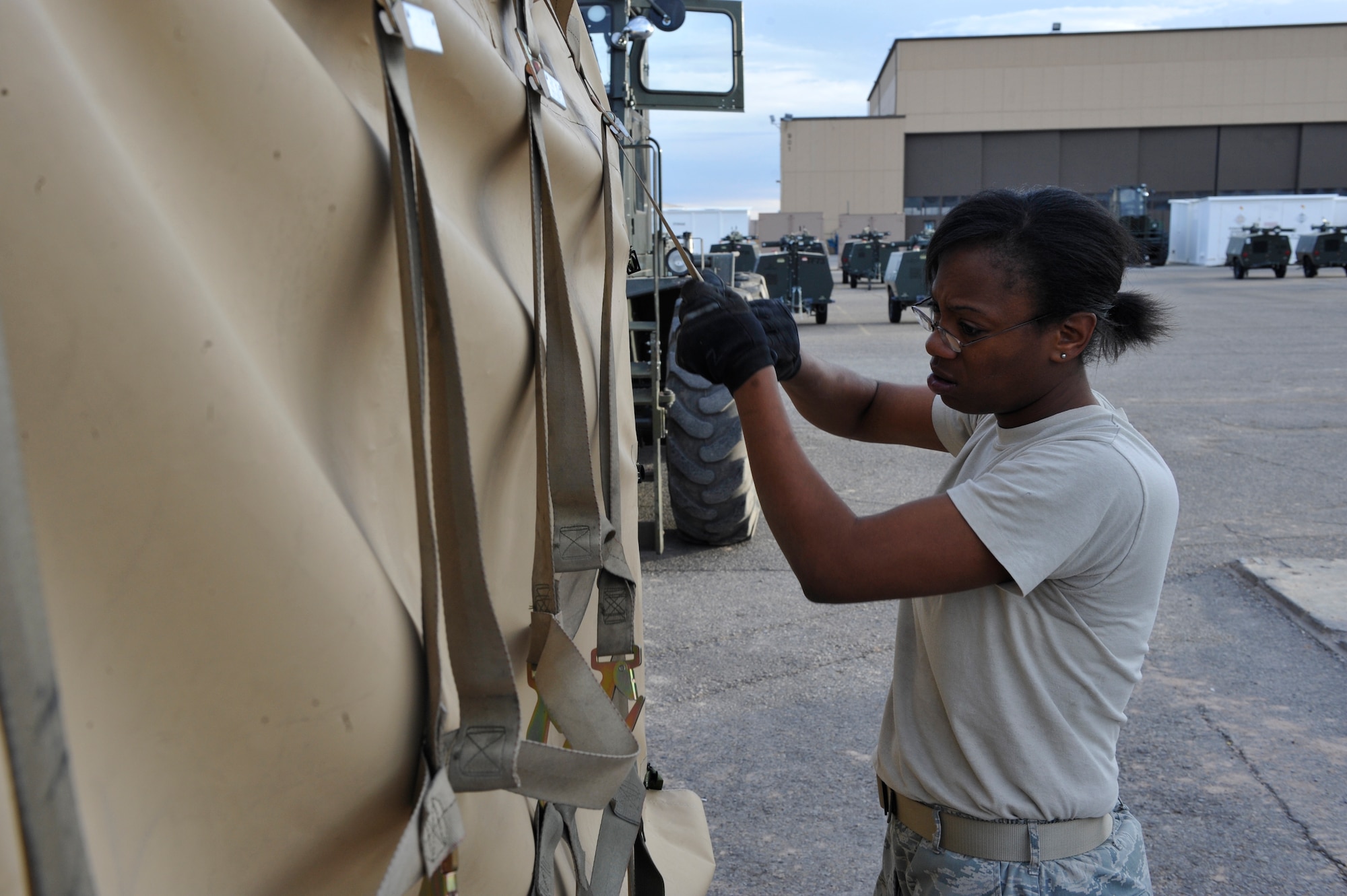 HOLLOMAN AIR FORCE BASE, N.M. -- Senior Airman Breanna Fuller, 49th Materiel Maintenance Group, straps down a 1500 reverse osmosis water purification unit, or ROWPU, preparing it for transportation here Jan. 17. The base is preparing tents, generators, air conditioning units, ROWPUs and personnel to send to Haiti after it was rocked by a 7.0-magnitude earthquake Jan. 12 leaving thousands dead and even more homeless. (U.S. Air Force photo by Staff Sgt. Anthony Nelson)
