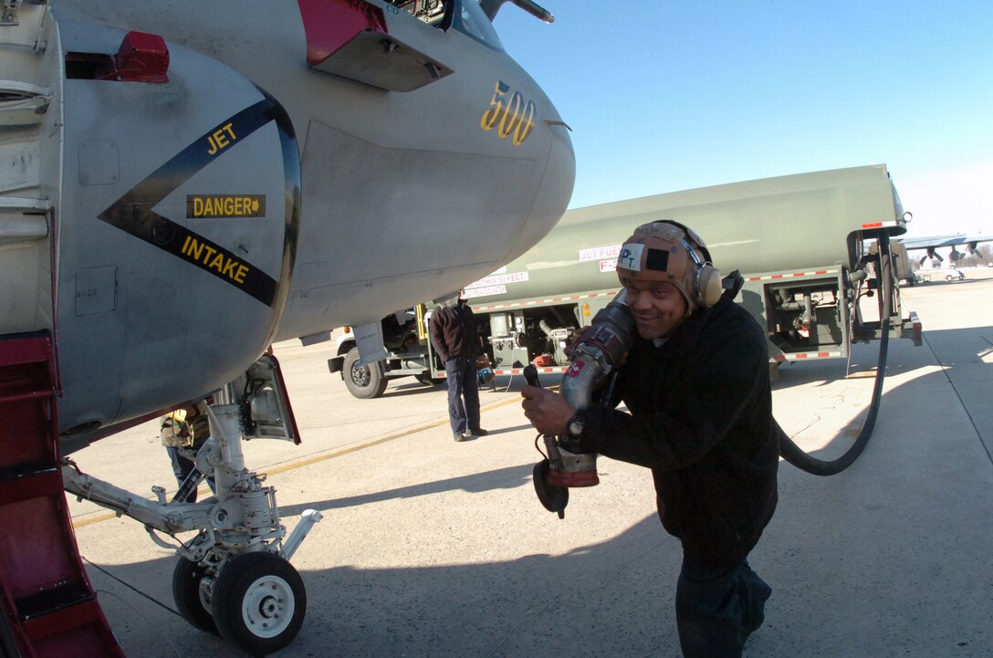 Aviation Ordnance 3rd Class Christopher Williams, Tactical Electronics Warfare Squadron 209, carries a refueling hose to refuel a squadron EA-6B “Prowler” aircraft prior to an upcoming mission on the eastside of Joint Base Andrews Wednesday. (U.S. Air Force photo by Bobby Jones)