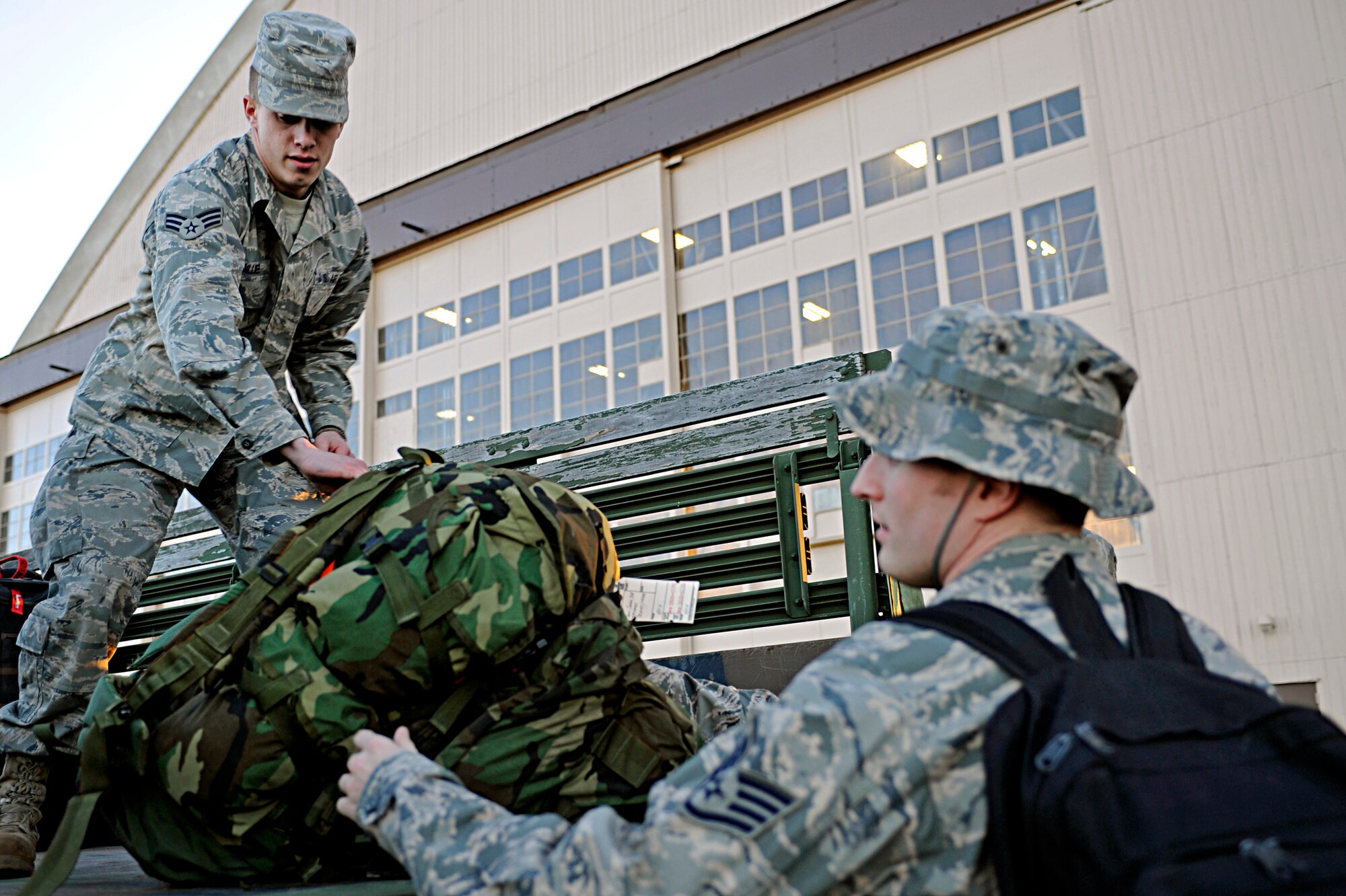 ELLSWORTH AIR FORCE BASE, S.D. -- (Left) Senior Airman Anthony Dillier, 28th Logistics Readiness Squadron vehicle operations technician, unloads deploying Airmen’s luggage, Jan. 17. More than 300 Airmen deployed to Southwest Asia to support today’s fight. This support includes aircrew, maintainers and other expeditionary combat support Airmen. (U.S. Air Force photo/Airman 1st Class Matthew Flynn)