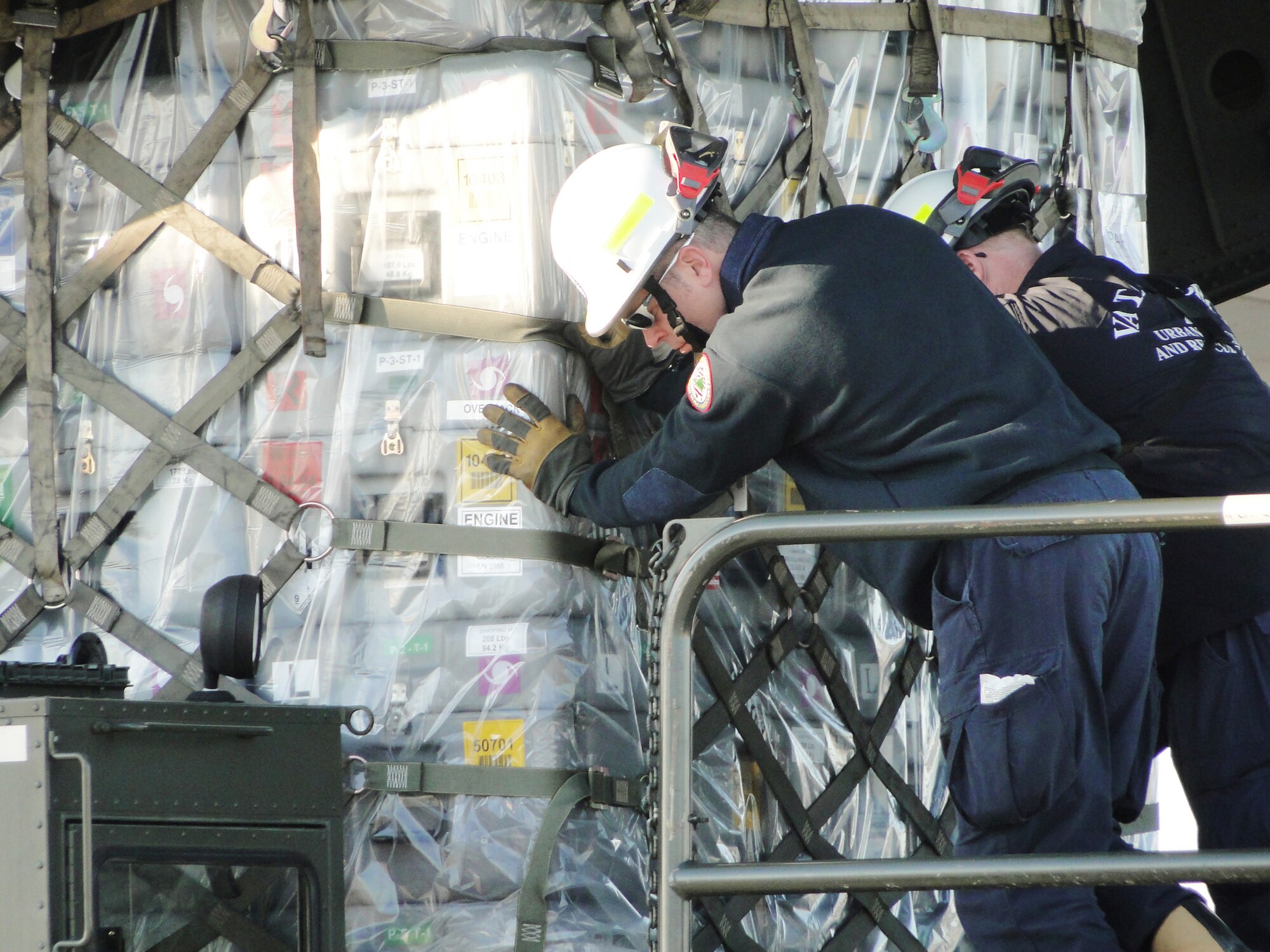 Members of Virginia Task Force 2, Federal Emergency Management Agency, load relief supplies onto a C-17 Globemaster III Jan. 15, 2010, at Chambers Field, Naval Station Norfolk, Va. The Virginia Beach-based FEMA urban search and rescue team departed for earthquake-stricken Haiti. The C17 is assigned to the 437th Airlift Wing. (U.S. Air Force photo/Capt. Ed Ekpoudom)                                
