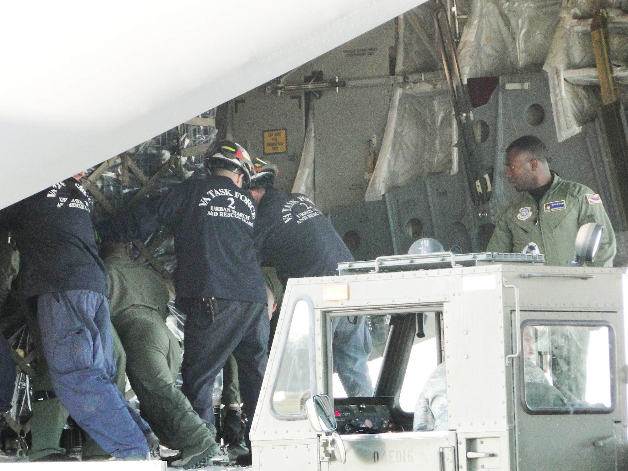 Members of Virginia Task Force 2, Federal Emergency Management Agency, and aircrew load relief supplies onto a C-17 Globemaster III, Jan. 15, 2010, at Chambers Field, Naval Station Norfolk, Va. The Virginia Beach-based FEMA urban search and rescue team departed for earthquake-stricken Haiti to support ongoing relief operations. The aircrew is assigned to 16th Airlift Squadron. (U.S. Air Force photo/Capt. Ed Ekpoudom)                                