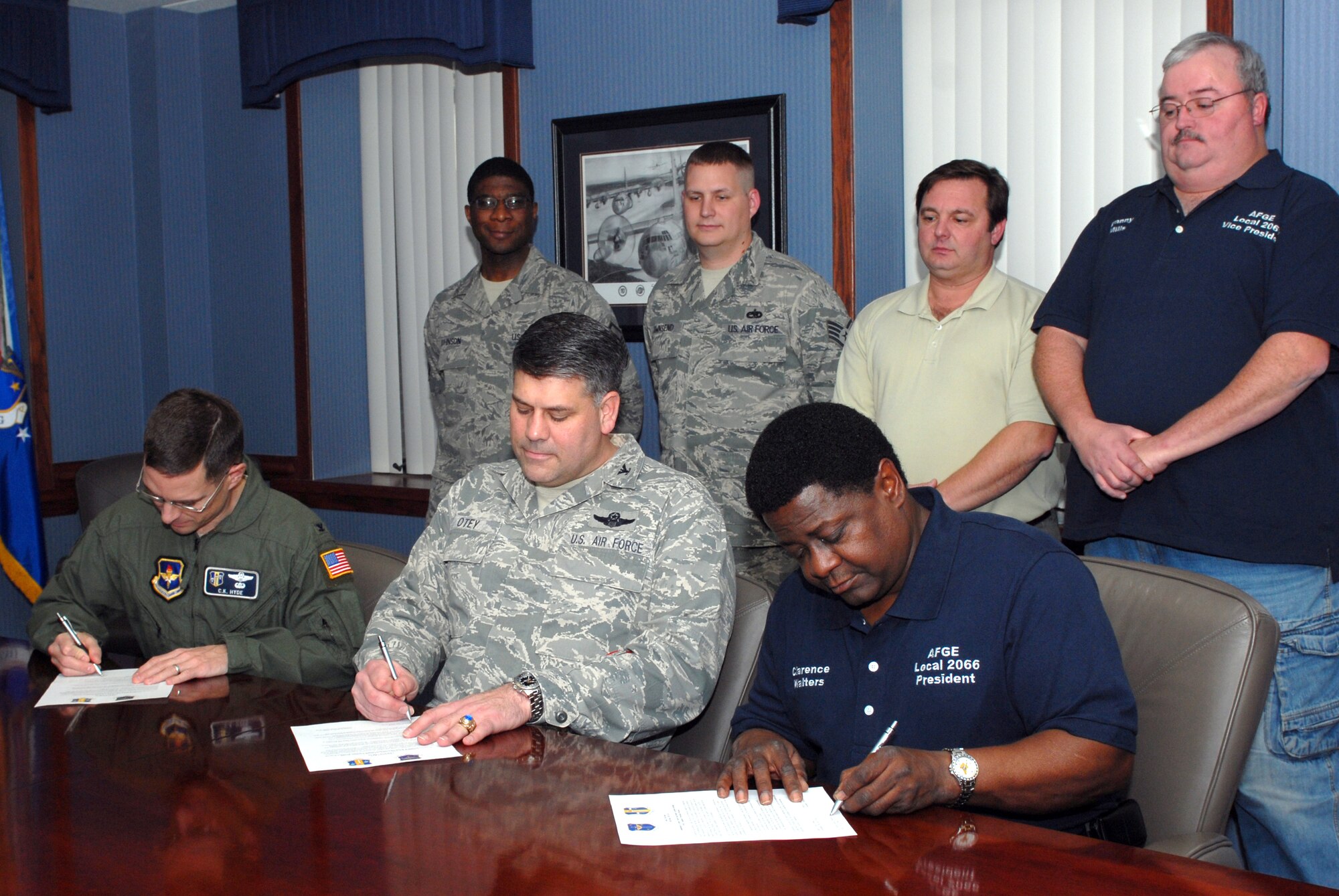 Col. C. K. Hyde, 314th Airlift Wing commander, Col. Greg Otey, 19th Airlift Wing commander, and Clarence Walters, American Federation of Government Employees local 2066 president, signs voluntary protection program commitment letters for Little Rock Air Force Base Jan. 14 while Master Sgt. Thomas Johnson, 19th Airlift Wing Safety ground safety craftsman; Staff Sgt. Peter Townsend, 314th Airlift Wing Safety flight safety NCO; Rick Myers, 19th Airlift Wing Safety ground safety manager; and Danny Mills, American Federation of Government Employees local 2066 vice president, watch as representatives to attain OSHA "Star Status." The letter specifies VPP objectives that management and the union support to eliminate work area hazards and ensure environmental, safety, and health excellence.(U.S. Air Force Photo by Senior Airman Christine Clark)