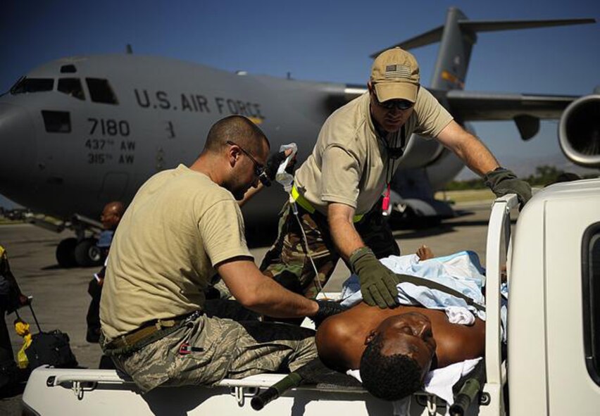 U.S. Air Force Master Sgt. Douglas Brook and Tech. Sgt. Nicholas Wentworth, both medics with the 1st Special Operations Support Squadron, Hurlburt Field, Fla., treat a Haitian man at the Troussaint L'Ouverture International Airport, Port-au-Prince, Haiti, Jan. 18, 2010. The man was injured during the earthquake that devastated the city Jan. 12, 2010. (U.S. Air Force photo by Master Sgt. Russell E. Cooley IV/Released)