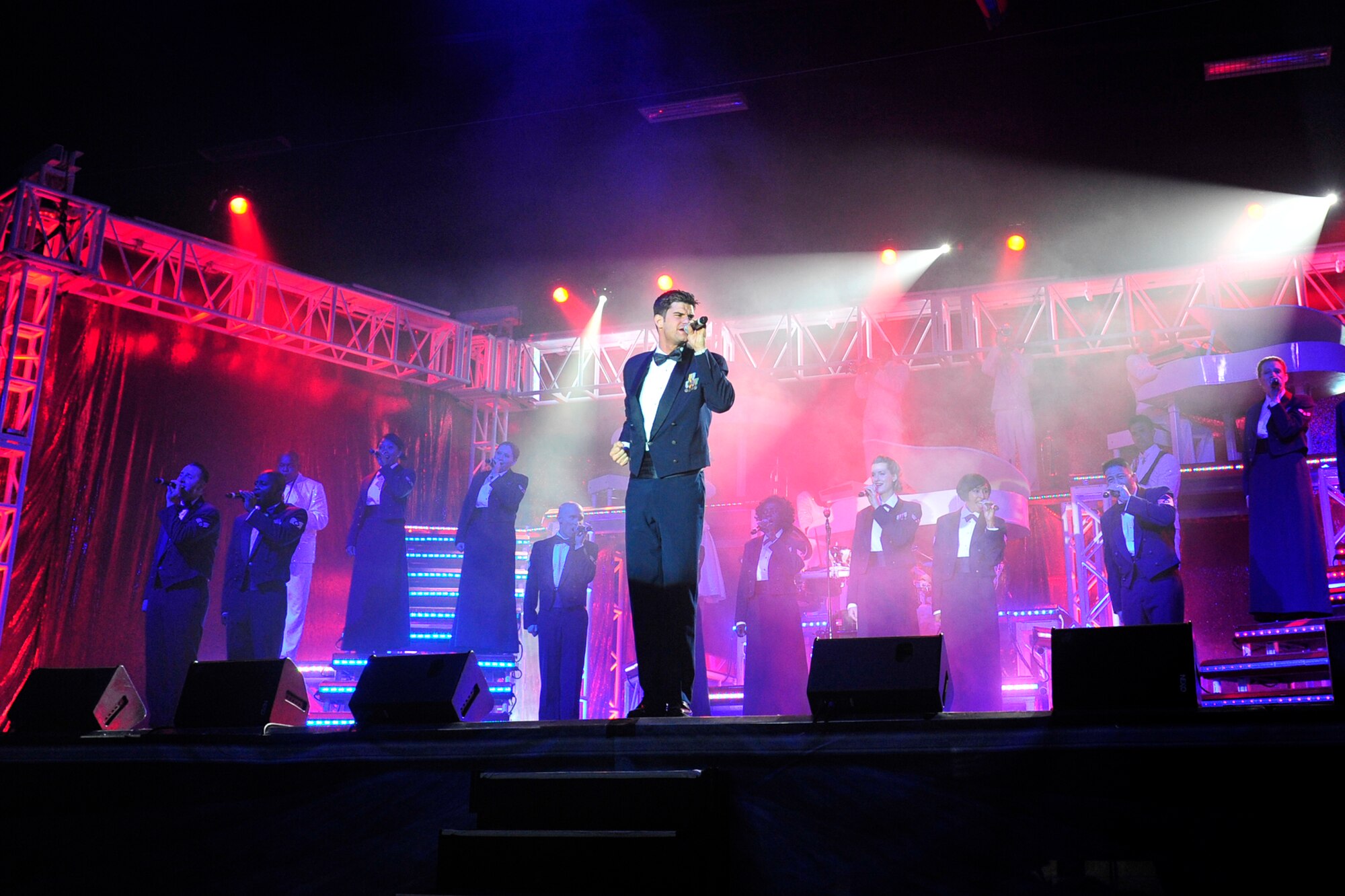 Staff Sgt. Robert Kalert, a Tops in Blues vocalist, leads the final performance of the night, singing "Proud to be an American" Jan. 14 at the base fitness center. Tops in Blue tours every year, visiting stateside bases and overseas locations. They provide expeditionary entertainment for Air Force members, families and members of the local community. (U.S. Air Force photo by Airman 1st Class Lausanne Pacheco)