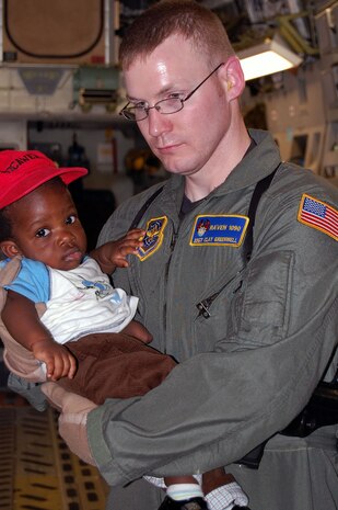 Staff Sgt. Clay Greenwell holds an American infant being evacuated from Haiti to Orlando Sanford International Airport, Fla., on a C-17 Globemaster III from McChord AFB, Wash., Jan. 18, 2010. Sergeant Greenwell is an Air Force Phoenix Raven specializing in in-flight and plane-side security at austere global locations. (U.S. Air Force photo/Master Sgt. Sean P. Houlihan)