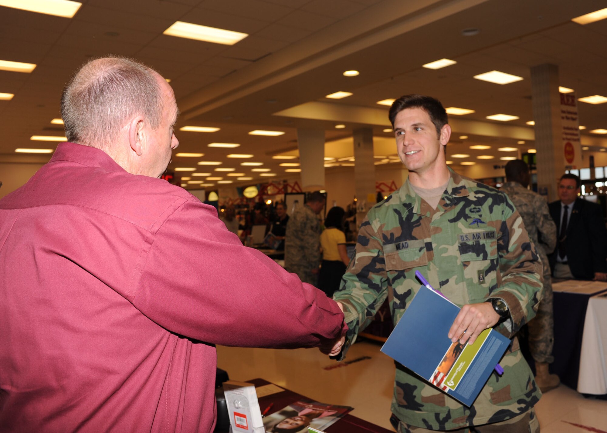 Senior Airman Jason Mead, 48th Rescue Squadron, speaks to a representative from the University of Phoenix at the College Day event here Jan. 15. This quarterly event is hosted by the Davis- Monthan Education center, and is open to all military members as well as dependents and retirees. Representatives from approximately 30 different colleges were on base to take part in the event and provide information about their institution and the different certification programs they offer. (U.S. Air Force photo/Airman Jerilyn Quintanilla)