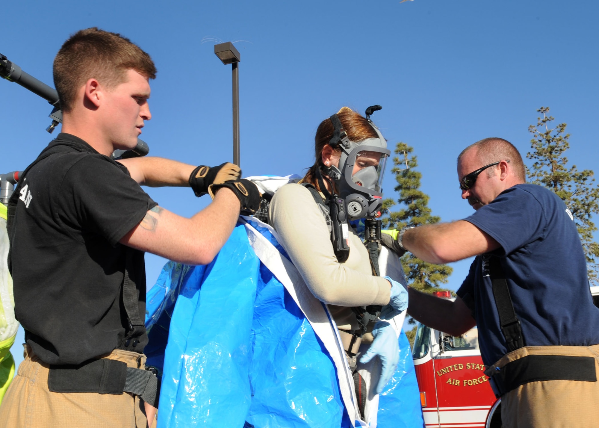 Airman 1st Class Steven White (left) and Mr. Joseph Benenati, both from the 355th Civil Engineer Squadron, assist Staff Sgt. Xavier Goco, 355th Aerospace Medicine Squadron, during an all hazards response training exercise here Jan. 13. Various squadrons took part in the exercise, to include the 355th Aerospace Medicine Squadron, the 355th Security Forces Squadron and the 355th Civil Engineer Squadron. The exercise was conducted to prepare base personnel in the event of a real emergency. (U.S. Air Force photo/Airman Jerilyn Quintanilla)

