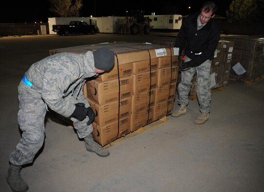 CANNON AIR FORCE BASE, N.M.-- Airman 1st Class Greg Strauch and Staff Sgt. Blake Jorgenson, 27th Special Operations Logistics Readiness Squadron pack one of the 11 pallets of MREs Jan 18. About 6,000 MRE's are headed for Haiti from Cannon as part of the worldwide relief effort.  (U.S. Air Force photo by Airman 1st Class Maynelinne De La Cruz)