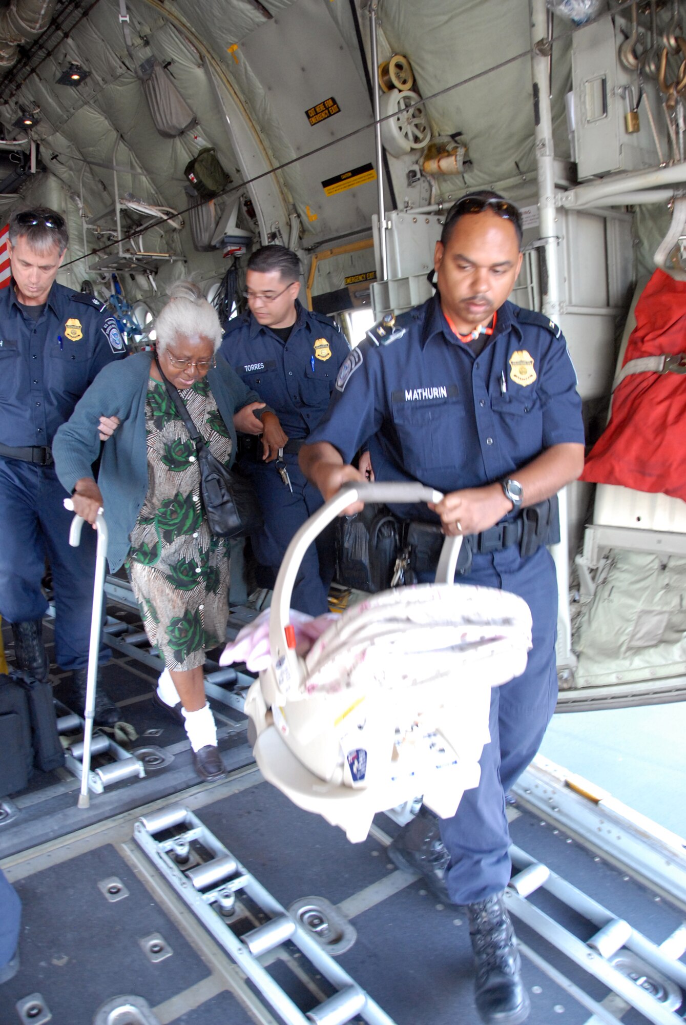 HOMESTEAD AIR RESERVE BASE, Fla. - U.S. Customs and Border Protection agents help and elderly Haitian lady and a baby from a C-130 aircraft assigned to the Minnesota Air National Guard. All personnel brought to Homestead ARB from Haiti must go through a Customs and Border Protection enforcement examimantion. (Air Force Photo/Master Sgt. Chance Babin)