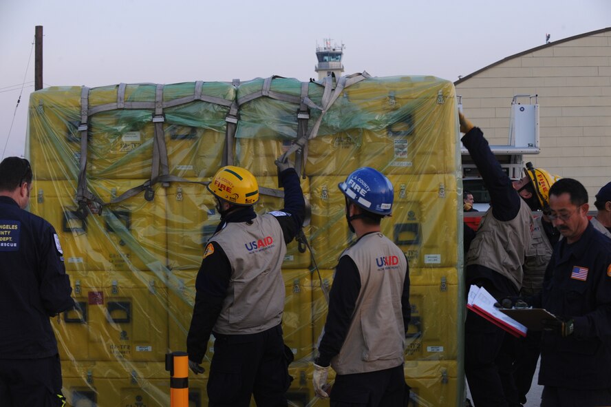 Members of the USAID urban search and rescue team from the Los Angeles County Fire Department arrange their rescue equipment at March Air Reserve Base, Calif., in preparation for their Jan. 13 flight to Port-Au-Prince, Haiti, to assist with the earthquake relief effort.  The C-17 Globemaster III that transported the 72-person team and their equipment is from the 60th Air Wing, Travis Air Force Base, Calif.  The aircraft arrived in Haiti Jan. 14. (U.S. Air Force Photo/Master Sgt. Roy Santana)