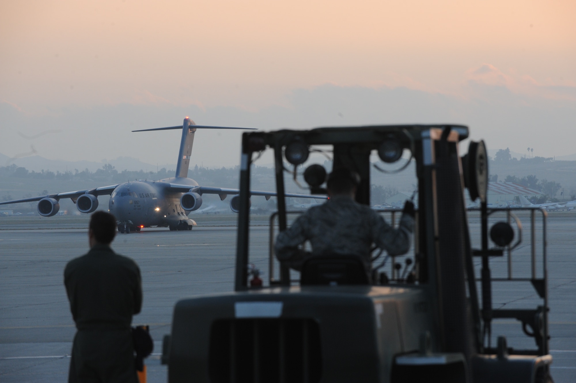 Airmen from the 452nd Aerial Support Flight load USAID equipment into a C-17 Globemaster III from the 60th Air Wing, Travis Air Force Base, Calif., parked at March Air Reserve Base, Calif., Jan. 13., 2010. The aircraft transported a 72-member urban search and rescue team and their supplies to help with the relief effort in Haiti following the devistating Jan. 12 earthquake. (U.S. Air Force Photo/Master Sgt. Roy Santana)