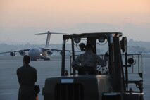 Airmen from the 452nd Aerial Support Flight load USAID equipment into a C-17 Globemaster III from the 60th Air Wing, Travis Air Force Base, Calif., parked at March Air Reserve Base, Calif., Jan. 13., 2010. The aircraft transported a 72-member urban search and rescue team and their supplies to help with the relief effort in Haiti following the devistating Jan. 12 earthquake. (U.S. Air Force Photo/Master Sgt. Roy Santana)