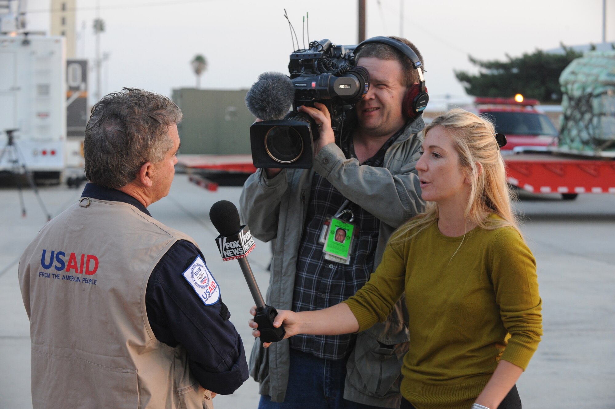 A Fox News camera team interviews a USAID member at March Air Reserve Base, Calif., Jan. 13.  The USAID urban search and rescue team from the Los Angeles County Fire Department was on base for a flight to Port-Au-Prince, Haiti, to assist with the earthquake relief effort.  The C-17 Globemaster III that transported the 72-person team and their equipment is from the 60th Air Wing, Travis Air Force Base, Calif.  The aircraft arrived in Haiti Jan. 14. (U.S. Air Force Photo/Master Sgt. Roy Santana)