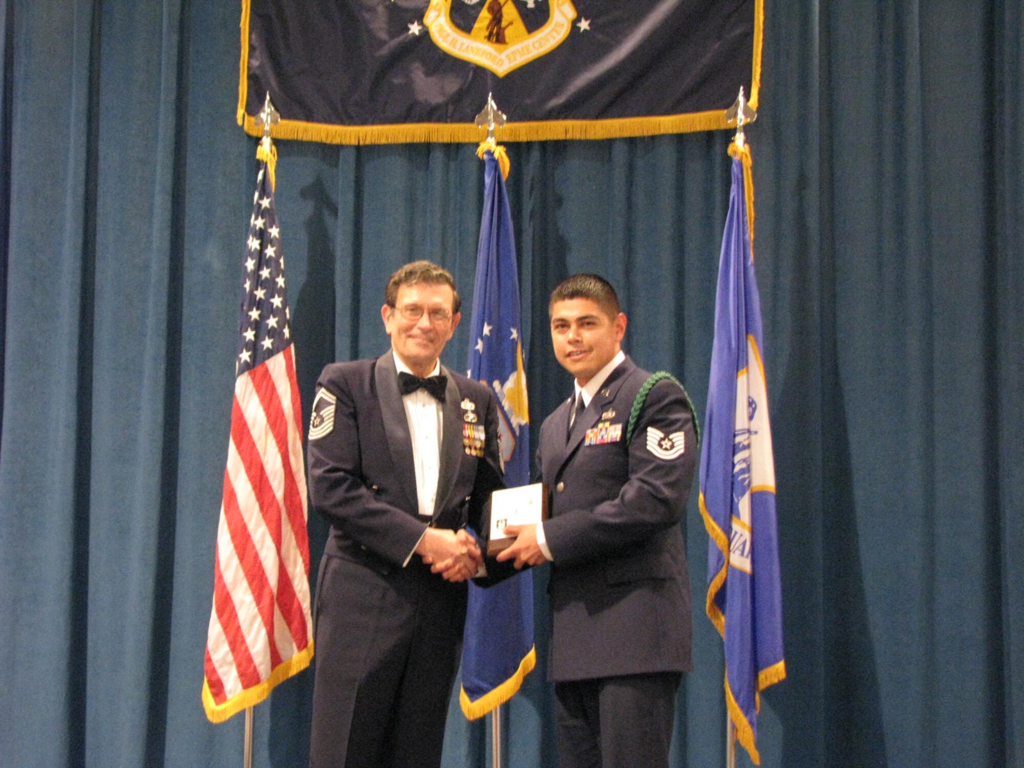 Technical Sgt Rodolfo Solis receives his diploma from Chief Master Sgt (Ret) Lynn Alexander at a Non-Commissioned Officer graduation ceremony at McGhee Tyson Air National Guard Base, TN on Dec. 15.  Solis was among 11 students from the Texas Air National Guard's 149th Figther Wing and 273rd Information Operations Squadron participating in an ANG satellite NCO professional education course where students take a portion of their courses locally and then conclude with a 17-day in-residence course at McGhee Tyson.  (U.S. Air Force photo by Chief Master Sgt Richard Pena)