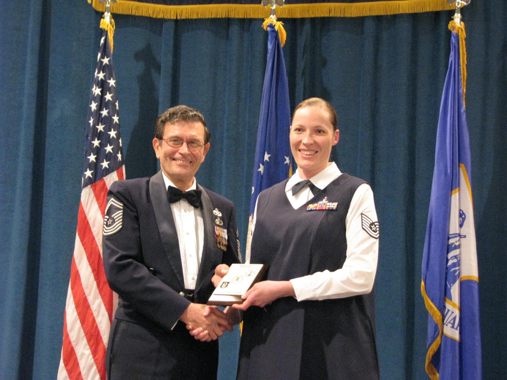 Technical Sgt Sarah Johnson receives her diploma from Chief Master Sgt (Ret) Lynn Alexander at a Non-Commissioned Officer graduation ceremony at McGhee Tyson Air National Guard Base, TN on Dec. 15.  Johnson was among 11 students from the Texas Air National Guard's 149th Fighter Wing and 273 Information Operation Squadron participating in an Air National Guard satellite NCO professional education course where students take a portion of their courses locally and then conclude with a 17-day in-residence course at McGhee Tyson.  