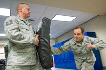 HANSCOM AIR FORCE BASE, Mass. -- During a 66th Security Forces Squadron augmentee training, held Jan. 12, 1st Lt. Brian Pedroza, 635th Electronic Systems Squadron, executes a closed mode weapon side strike while Tech Sgt. Wayne Griggs, 66 SFS, holds a protective pad and provides feedback. Security forces augmentees are individuals outside the 66 SFS who train to assist the unit if additional help is needed.   (U.S. Air Force photo by Mark Wyatt)