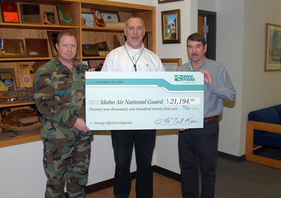 Mr. Dan Smith, Energy Efficiency Representative for Idaho Power, presents a check to Mr. Scott Busmann and Tech. Sgt. Travis Jones of the 124th Civil Engineer Squadron Dec. 29. The check represents money credited to the 124th Fighter Wing's electric account for energy efficiencient upgrades to facilities on Gowen Field. (Air  Force photo by Master Sgt. Tom Gloeckle)