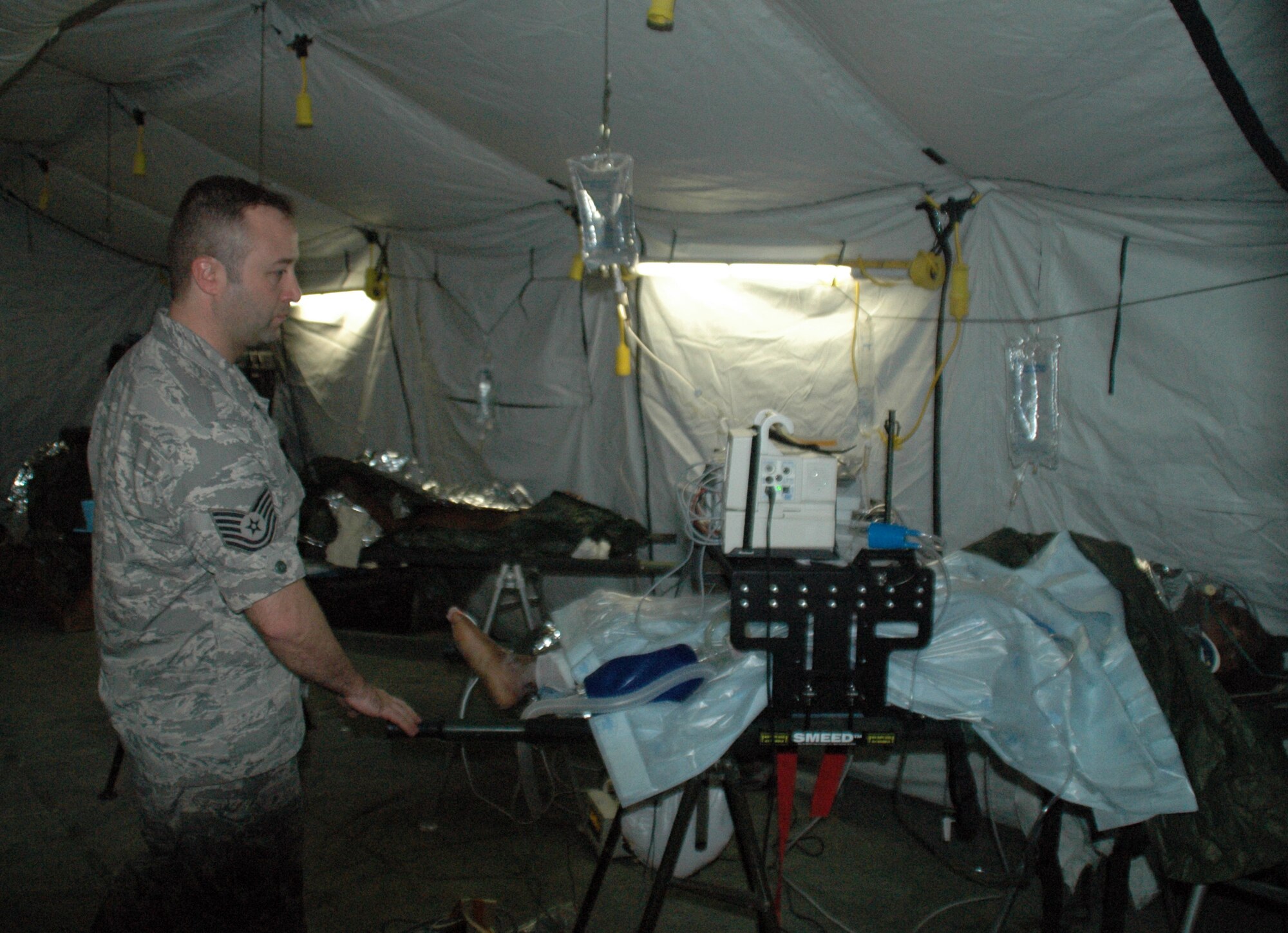 Tech. Sgt. Jeff Kelly, 315th AW Public Affairs visits with survivors of the earthquake who had been pulled from beneath the rubble only hours before. Air Force medical personnel are working around the clock to help injured survivors of the earthquake. (U.S. Air Force photo/Major Bill Walsh)