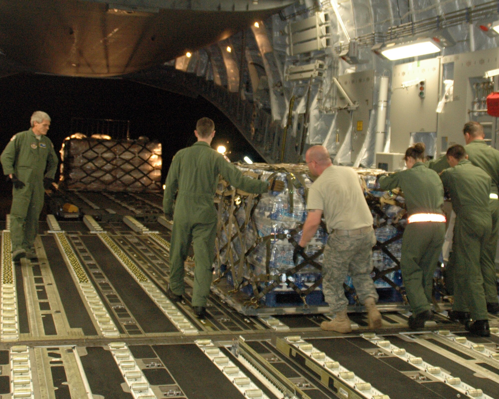 Senior Master Sgt. Ben Alexander, 315th AW Operations Support Squadron supervises the offload of humanitarian relief supplies from a C-17 in Port-au-Prince, Haiti. Supplies are being flown into the earthquake ravaged country around the clock by members of Team Charleston. (U.S. Air Force photo/Tech. Sgt. Jeff Kelly)