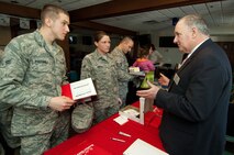 Airman 1st Class Patryk Podsiadlo and A1C Kari Snyder from the 66th Medical Group, discuss education options with J. Gerard Keegan, Boston University Metropolitan College assistant professor, at the Hanscom Education and Training Center's Education Fair, held Jan. 14 at the Minuteman Club.  (U.S. Air Force photo by Rick Berry)