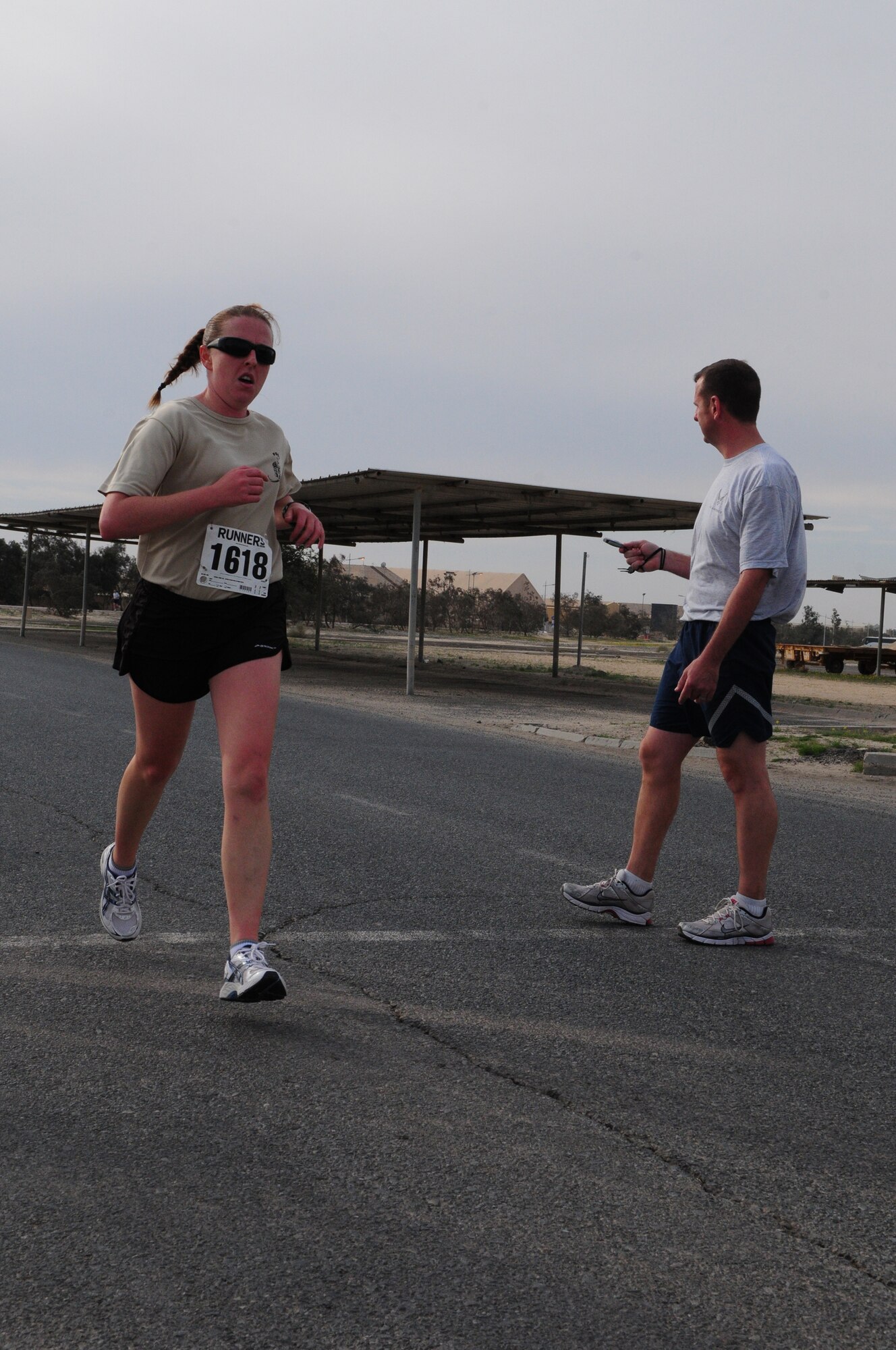 Australian Cpl. Cath Deeks, crosses the 10-kilometer finish line Jan. 18, 2010 during the Armed Forces MLK Run at an air base in Southwest Asia. Corporal Deeks placed first in the women's category with a time of 49:58. About 150 servicemembers, Department of Defense civilian and contract personnel and coalition partners participated in the 10- and 5-kilometer race honoring Martin Luther King Jr. The event was sponsored by HFP Racing. (U.S. Air Force photo by Staff Sgt. Robert Sizelove/Released)