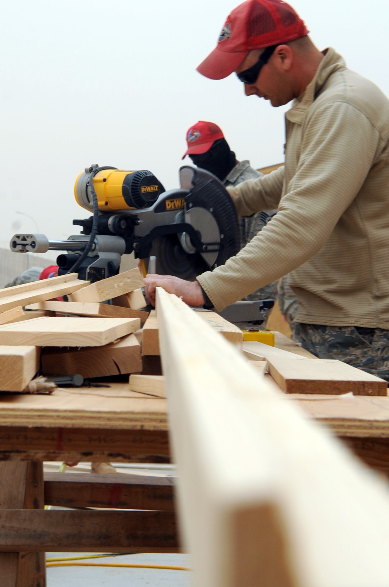 Airman 1st Class Bruce Ramsey from the 557th Expeditionary RED HORSE Squadron uses a chop saw to cut a 2/4 structure on Joint Base Balad, Iraq, Jan. 13, 2010. RED HORSE squadrons construct some of the structures needed by contingency and special operations worldwide. (U.S. Air Force photo/Senior Airman Brittany Y. Bateman/Released)