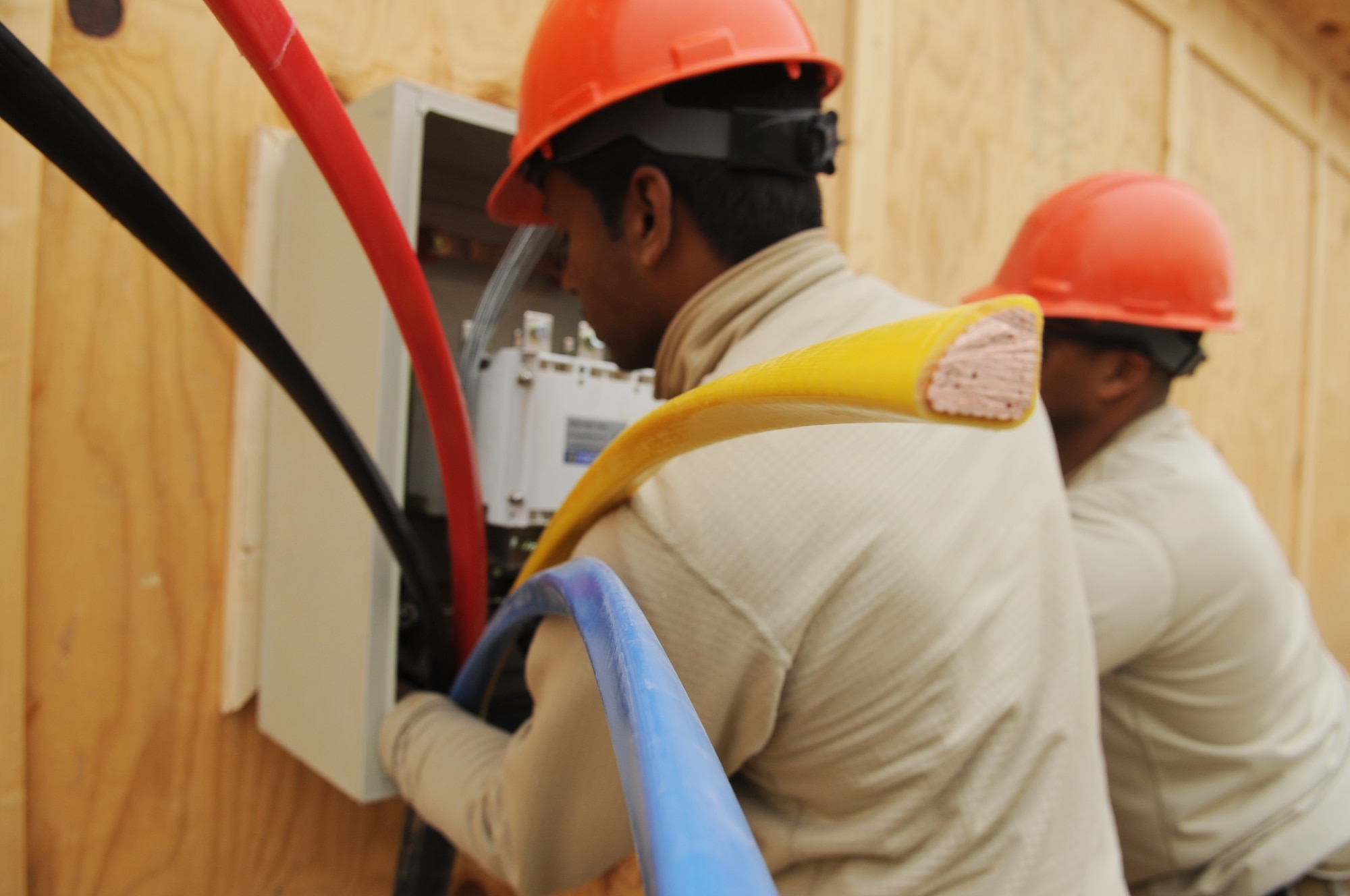 Senior Airman Pedro Lora-Torres, 557th Expeditionary RED HORSE Squadron electrical systems journeyman, prepares the main distribution cable to an additional badging office on Joint Base Balad, Iraq, Jan. 13, 2010. Airmen from the 557th ERHS built the office so more foreign nationals can get through the gate in a timely manner. (U.S. Air Force photo/Senior Airman Brittany Y. Bateman/Released)