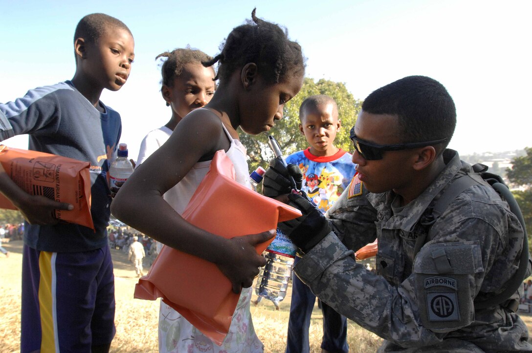 U.S. Army Spc. Juan Valencia marks the fingernail of a small girl to indicate she has gone through the distribution line in Port-au-Prince, Jan. 18, 2010. Valencia is with the 82nd Airborne Division's 1st Squadron, 73rd Cavalry Regiment. The squadron established the forward operating base three days ago and has already passed out thousands of meals and bottles of water.
