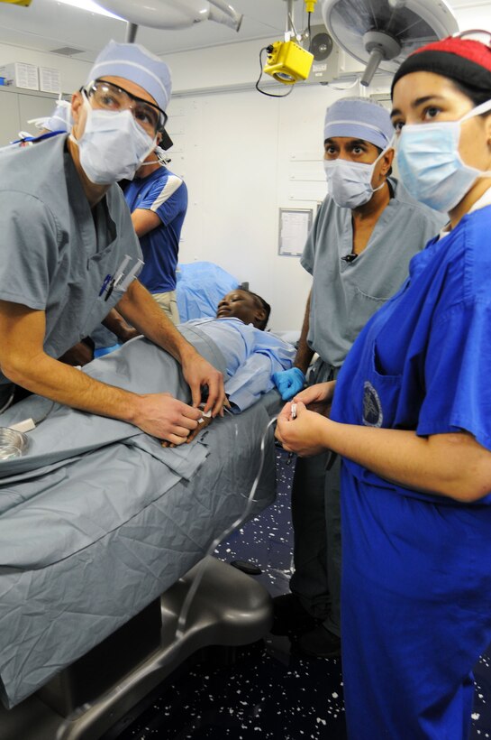 U.S. Navy Cmdr. Jerry Berman, left, Dr. Henri R. Ford, Dr. Sanjay Gupta,  and Lt. Cmdr. Kathryn Berndt prepare a 12-year-old Haitian girl with a severe head injury for surgery aboard the aircraft carrier USS Carl Vinson, Port-Au-Prince, Haiti, Jan. 18, 2010. Berman and Berndt are Navy surgeons assigned to the USS Carl Vinson. Ford, originally from Haiti, is surgeon-in-chief at Los Angeles Pediatric Hospital. Gupta is a CNN medical correspondent and practicing neurosurgeon.