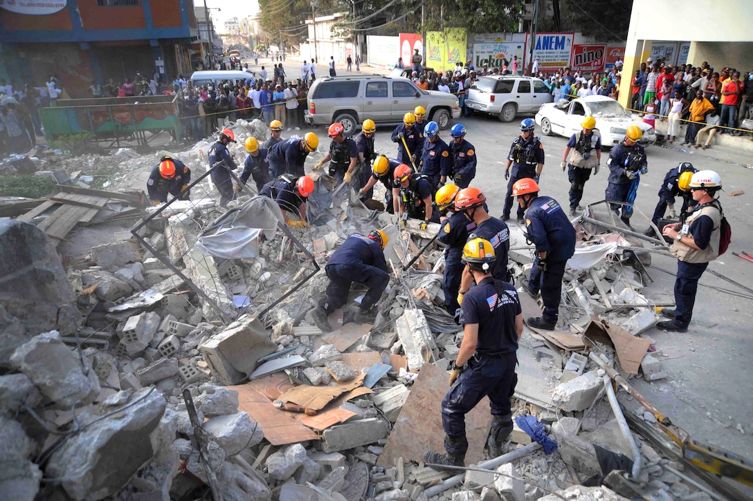 Members of the Los Angeles County Fire Department Search and Rescue Team clear debris at a collapsed building in downtown Port-au-Prince, Haiti, Jan. 17, 2010.