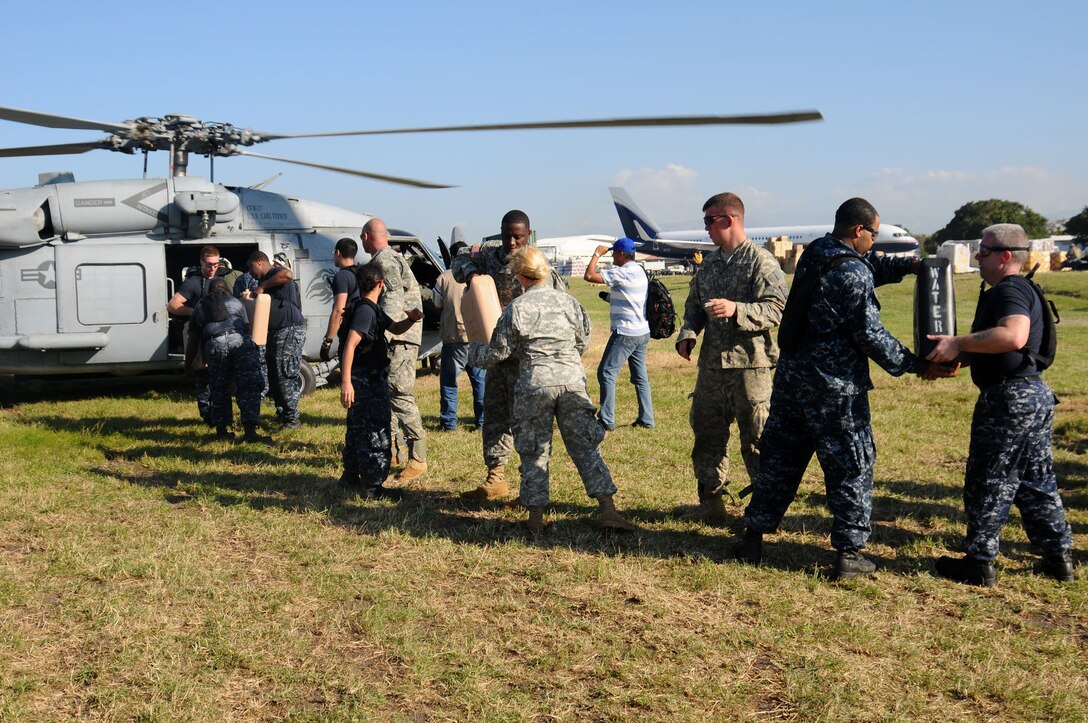 U.S. military members unload water from a helicopter at the airport at Port-au-Prince, Haiti, Jan. 18, 2010. The Carl Vinson and Carrier Air Wing 17 are conducting humanitarian and disaster relief operations as part of Operation Unified Response after a 7.0 magnitude earthquake caused severe damage near Port-au-Prince Jan. 12, 2010.
