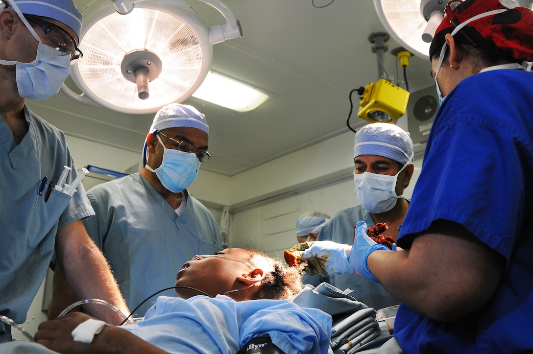 From left, U.S. Navy surgeon Cmdr. Jerry Berman, Dr. Henri R. Ford, the surgeon in chief of Los Angles Pediatric Hospital, Dr. Sanjay Gupta, a CNN medical correspondent and practicing neurosurgeon originally from Haiti, and Navy surgeon Lt. Cmdr. Kathryn Berndt prepare a 12-year-old Haitian girl with a severe head injury for surgery aboard the aircraft carrier USS Carl Vinson off Haiti, Jan. 18, 2010. The surgeons removed a piece of concrete from the child's brain.