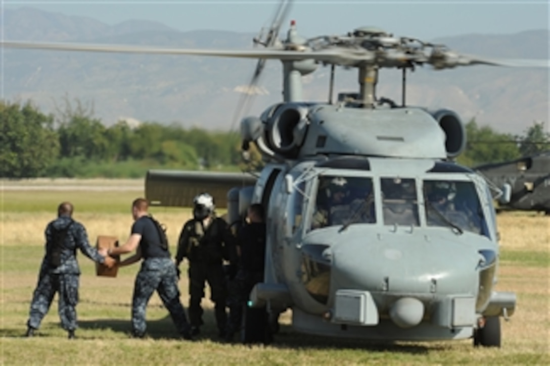 U.S. Navy sailors load humanitarian supplies onto a Navy HH-60 Pave Hawk helicopter from Naval Air Station Jacksonville, Fla., at Toussaint L’Ouverture International Airport in Port-au-Prince, Haiti, to be taken into the city for distribution on Jan. 18, 2010.  Department of Defense assets have been deployed to assist in the Haiti relief effort following a magnitude 7.0 earthquake that hit the city Jan. 12, 2010.  