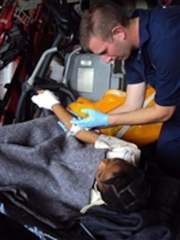 A U.S. Coast Guardsman from USCGC Tahoma (WMEC 908) tends to an injured Haitian woman off the coast of Port-au-Prince, Haiti, as he prepares her for transport aboard a Coast Guard helicopter for additional medical treatment on Jan. 17, 2010.  Haiti was hit by a 7.0 magnitude earthquake on Jan. 12, 2010.  