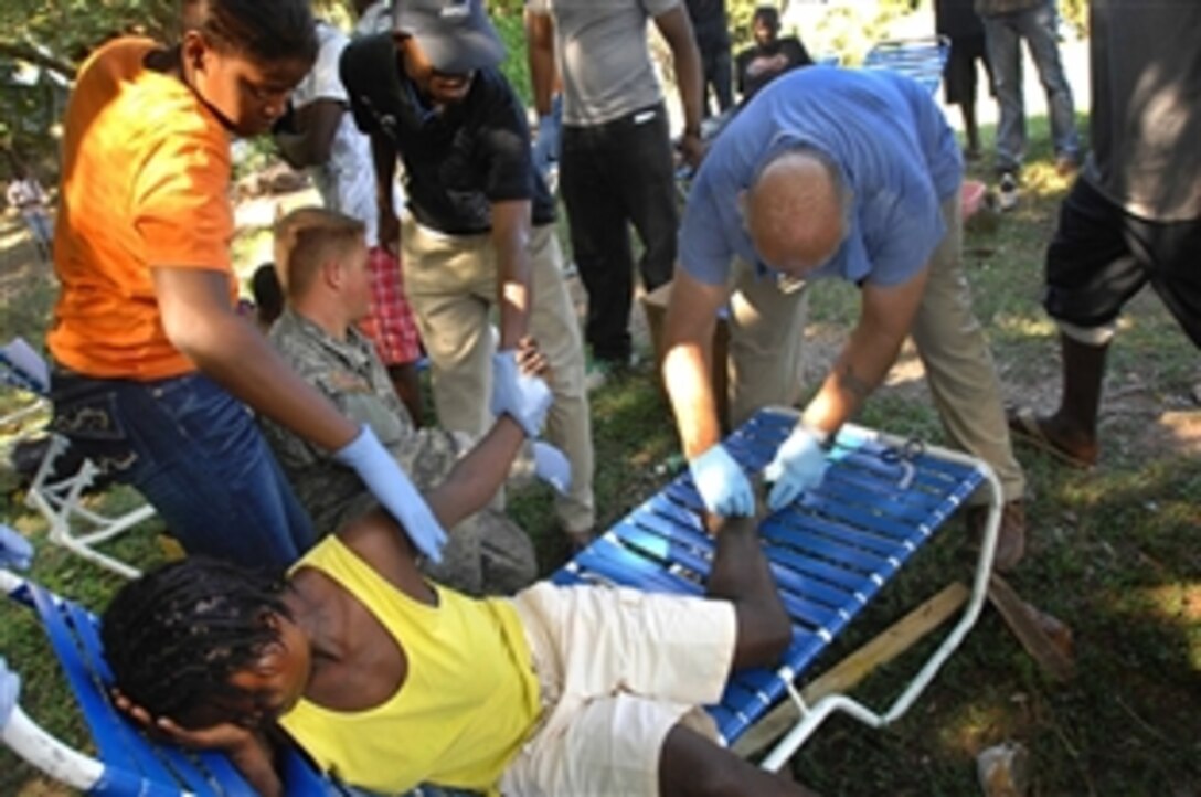 Combat medics and Haitian medical volunteers treat patients at the forward operating base set up by U.S. Army soldiers in Port-au-Prince, Haiti Jan. 18, 2010. The soldiers are assigned to the 82nd Airborne's 1st Squadron, 73rd Cavalry Squadron. The squadron does not have the supplies to establish a clinic, but soldiers are seeing patients at the base with the supplies they have. They are looking for additional resources such as area clinics, where they can send the more critical patients.