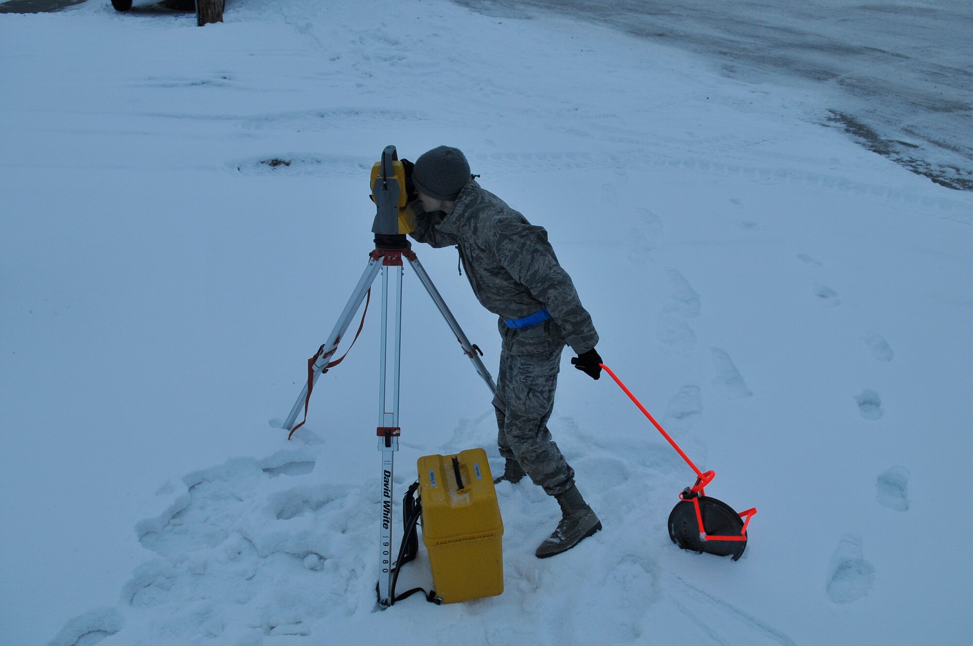 Airman 1st Class Kyle Riggenbach looks through surveying equipment Jan. 15, 2010, Eielson Air Force Base. Surveying is a way to find the exact location of a known position. Airman Riggenbach is a 354th Civil Engineer Squadron Geobase Flight geographic information system technician. (U.S. Air Force photo/Airman 1st Class Janine Thibault)