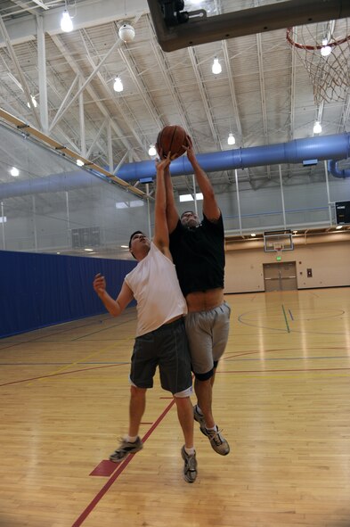 MINOT AIR FORCE BASE, N.D. -- Tech. Sgt. William Huerta, 5th Maintenance Squadron environmental electrical systems craftsman battles Airman 1st Class Bryan Eldred, 5th Maintenance Squadron EES apprentice, for a rebound during a basketball game here Jan. 20. Physical fitness is an important factor in the Air Force way of life, as members are encouraged to work out at least three days a week. (U.S. Air Force photo by Senior Airman Sharida Jackson)