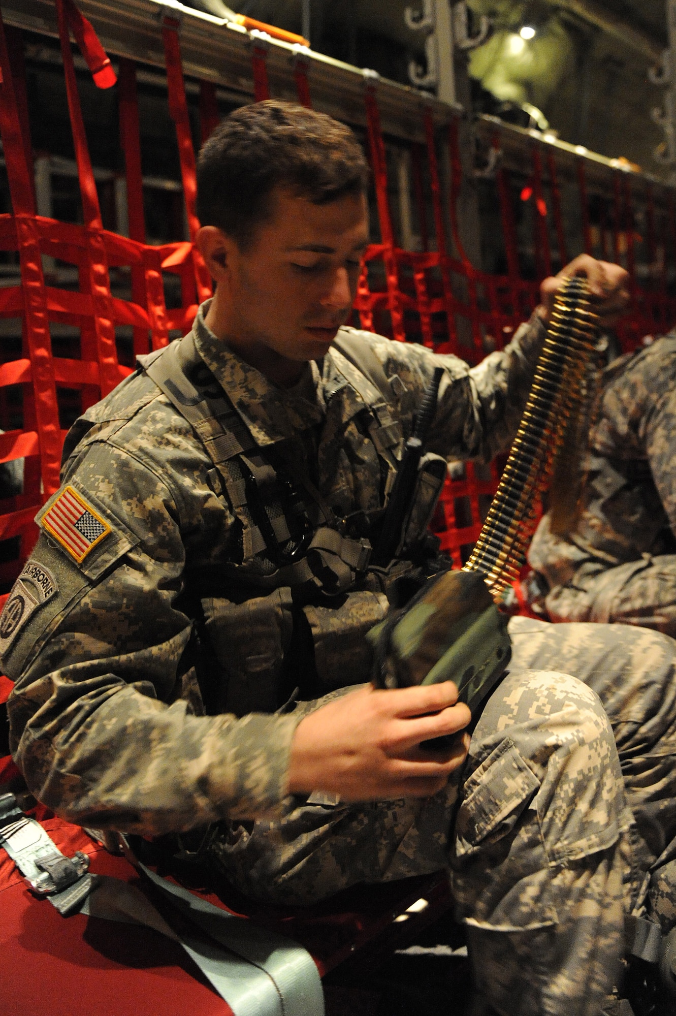 U.S. Army Spc. Ralph Libby, 82nd Airborne Division infantry, load a Squad Automatic Weapon, M249 Light Machine Gun pouch with a 200mm round disintegrating belt holding the 5.56mm cartridge rounds during a stop at MacDill Air Force Base, Fla., Jan. 19, 2010. Spc. Libby and other Soldiers from the 82nd Airborne will be supporting the earthquake relief during the earthquake relief efforts in support of Operation Unified Response. (U.S. Air Force photo/Staff Sgt. Chad Chisholm)