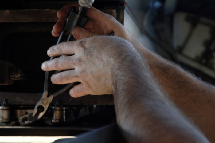 Airman 1st Class Graham Robinson grips a pair of safety wire pliers during a repair on a C-17 engine here after a reverse engine thruster is damaged in flight en route from Haiti back to Charleston AFB Jan 19, in support of humanitarian relief operations. The humanitarian efforts are both coalition and joint and have been running around the clock since the 7.0-magnitude earthquake which occurred Jan. 12. Airman Robinson is an aircraft maintenance technician with the 437th Aircraft Maintenance Squadron. (U.S. Air Force photo/Airman 1st Class Lauren Main)