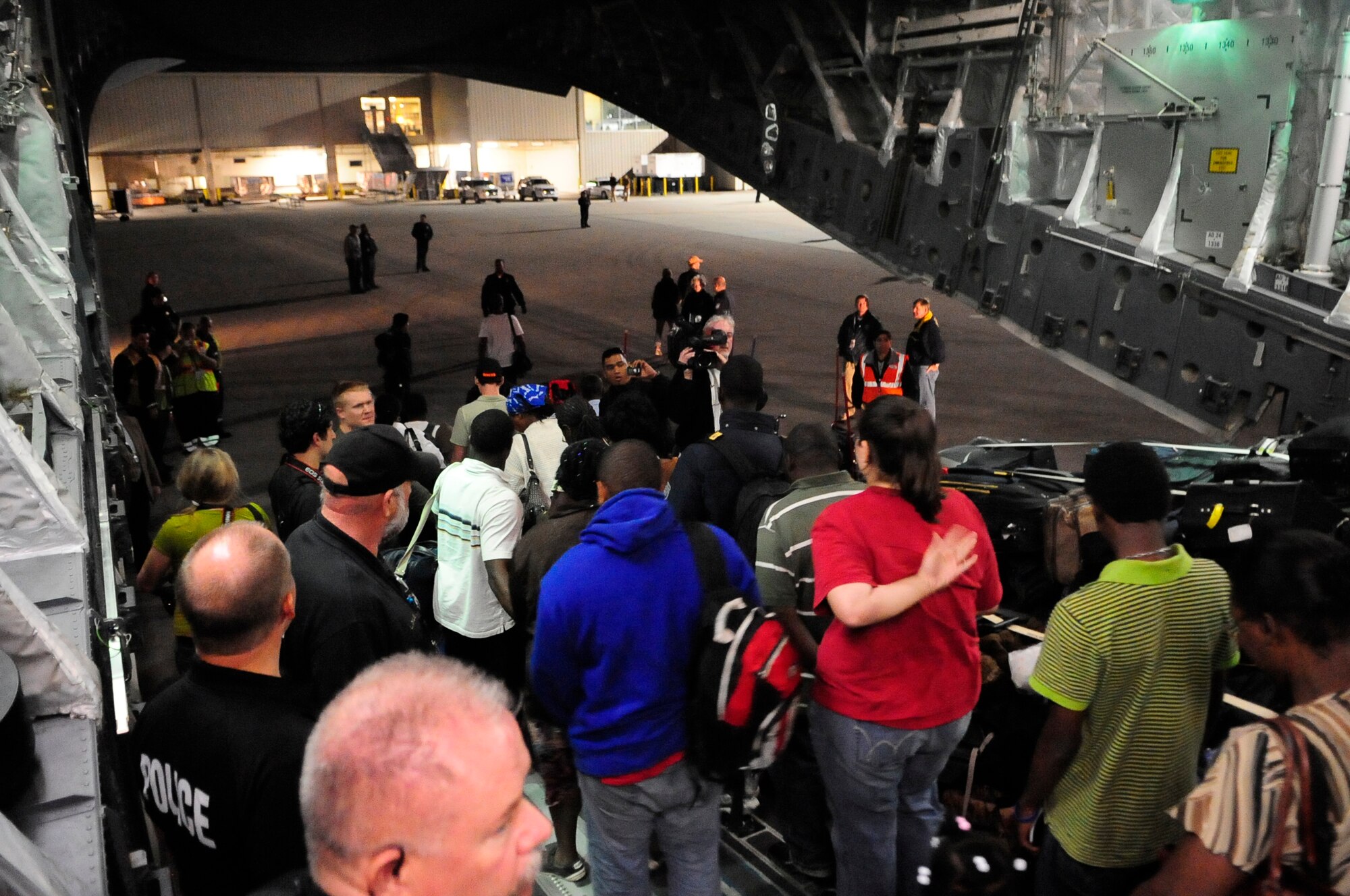 Evacuees exit a McChord C-17 at the Orlando International Airport in Orlando, Fla. Sunday.  The aircraft transported approximately 186 people from Port-Au-Prince’s Toussaint L’Ouventure International Airport, delivering them safely to Orlando. (U.S. AirForce photo/Master Sgt. Chris Haylett)