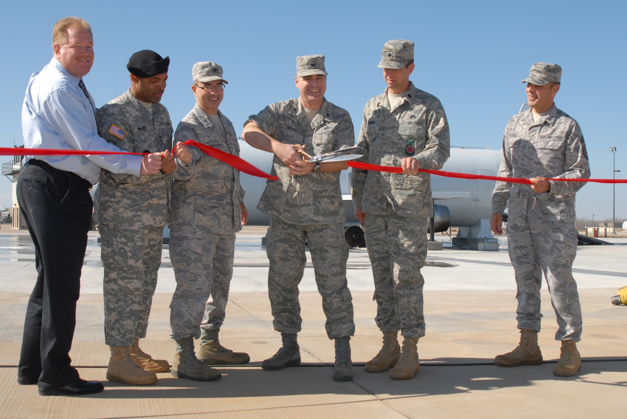 GOODFELLOW AIR FORCE BASE, Texas -- Col. Thomas Geary, 17th Training Wing commander, cuts the ribbon during the ribbon-cutting ceremony for the new large frame aircraft trainer, Jan. 20, 2010. The new trainer replaces the 11 year old trainer that had become unsafe due to extensive use. Pictured from left to right are Graham Huxley, Kidde Fire Trainers representative, Army Sgt. 1st Class Omar Moore, 344th Military Intelligence Battalion, Col. Anthony Lombardo, 17th Training Group commander, Colonel Geary, Lt. Col. Jeffrey McBride, 312th Training Squadron commander, and Chief Master Sgt. Frederick Ricker, 17th TRW command chief master sgt. (U.S. Air Force photo/Staff Sgt. Laura McFarlane)
