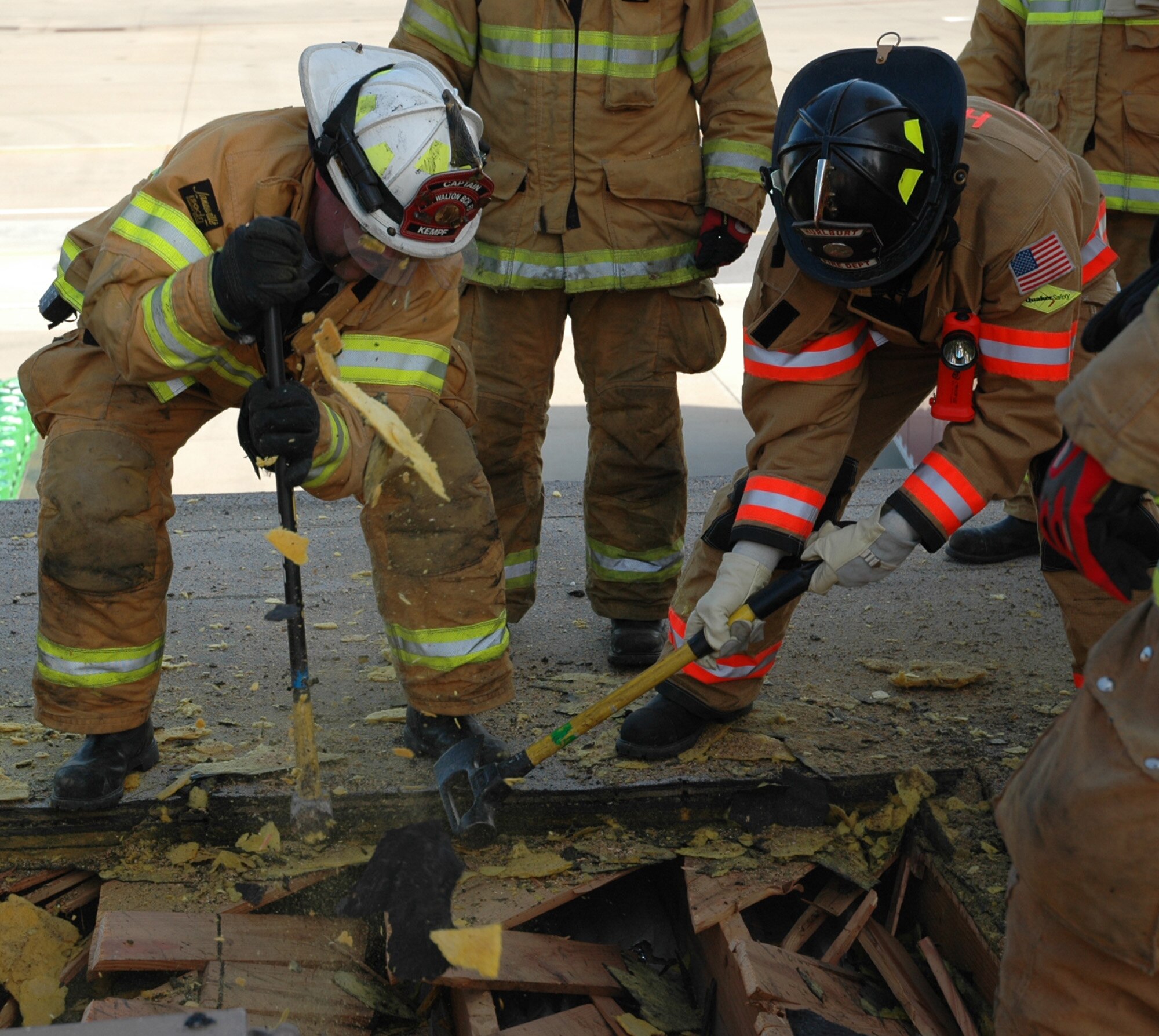 Firefighters from Hurlburt Field and local fire departments use hammers to break open a section of the old Hurlburt Field Fire Department's roof Jan. 13. Teams used chainsaws and axes over specific sections with the location of the fire and the building’s structural integrity in mind. (U.S. Air Force photo by Airman 1st Class Joe McFadden)