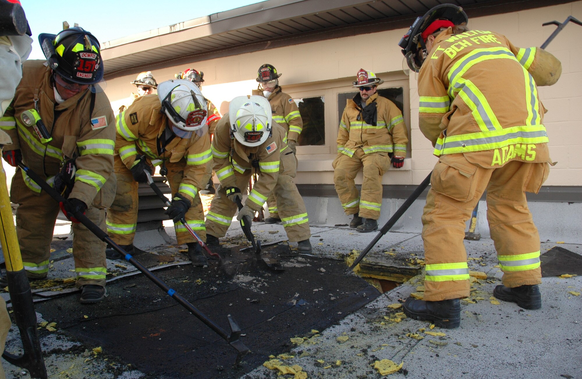 Firefighters from Hurlburt Field and local fire departments  peel back tar-sealed layers of roofing atop the old Hurlburt Field Fire Department Jan. 13. Teams used chainsaws and axes over specific sections with the location of the fire and the building’s structural integrity in mind. (U.S. Air Force photo by Airman 1st Class Joe McFadden)
