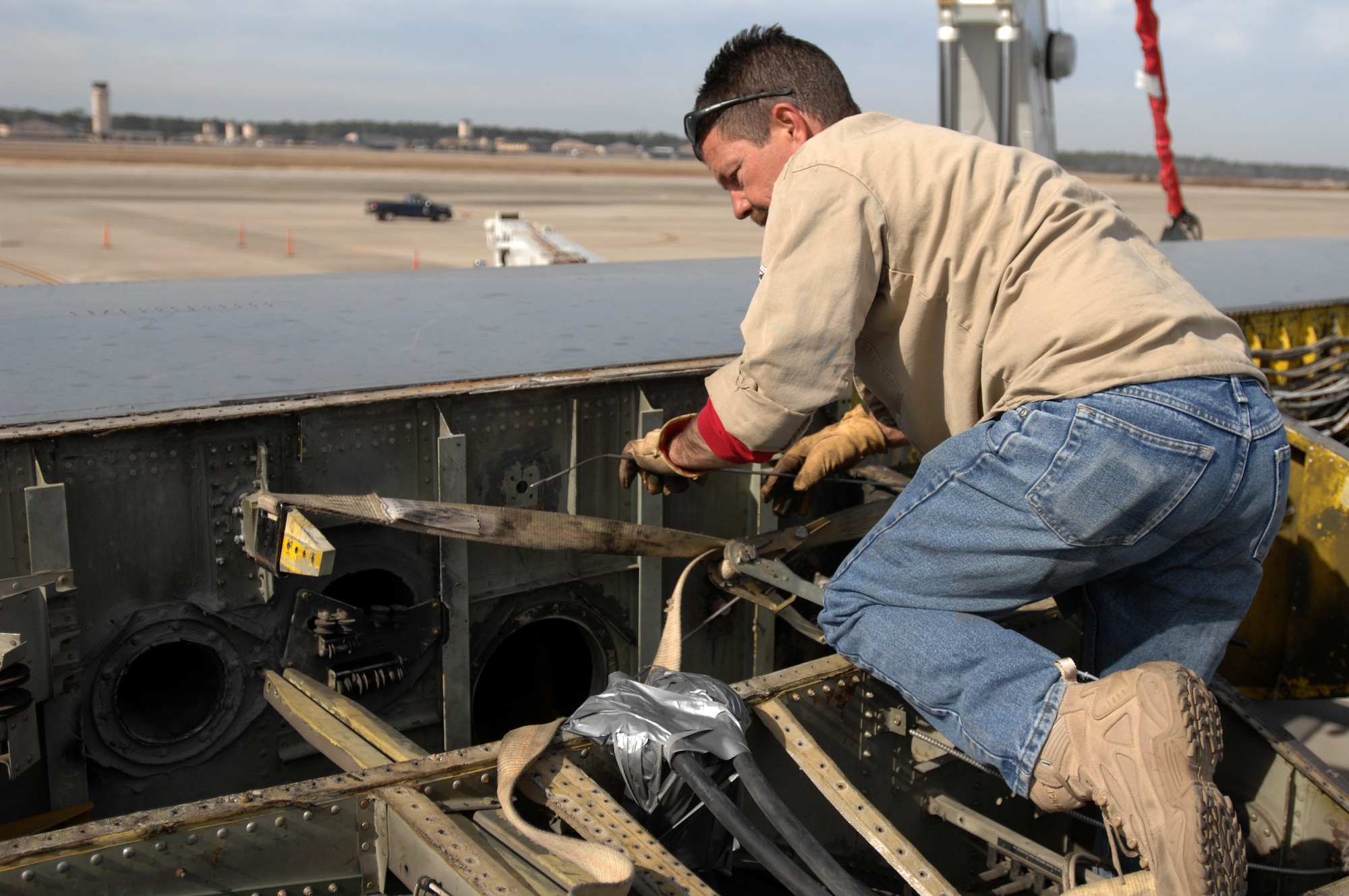 Sean Hofhine, a contractor with Southwest Industrial Rigging, preps a wing as it is lowered on to a C-130E fuselage outside the 19th Special Operations Squadron at Hurlburt Field Jan. 14. The aircraft will be used as a simulator for ground, loading and maintenance training beginning in March. (U.S. Air Force photo by Senior Airman Matt Loken)