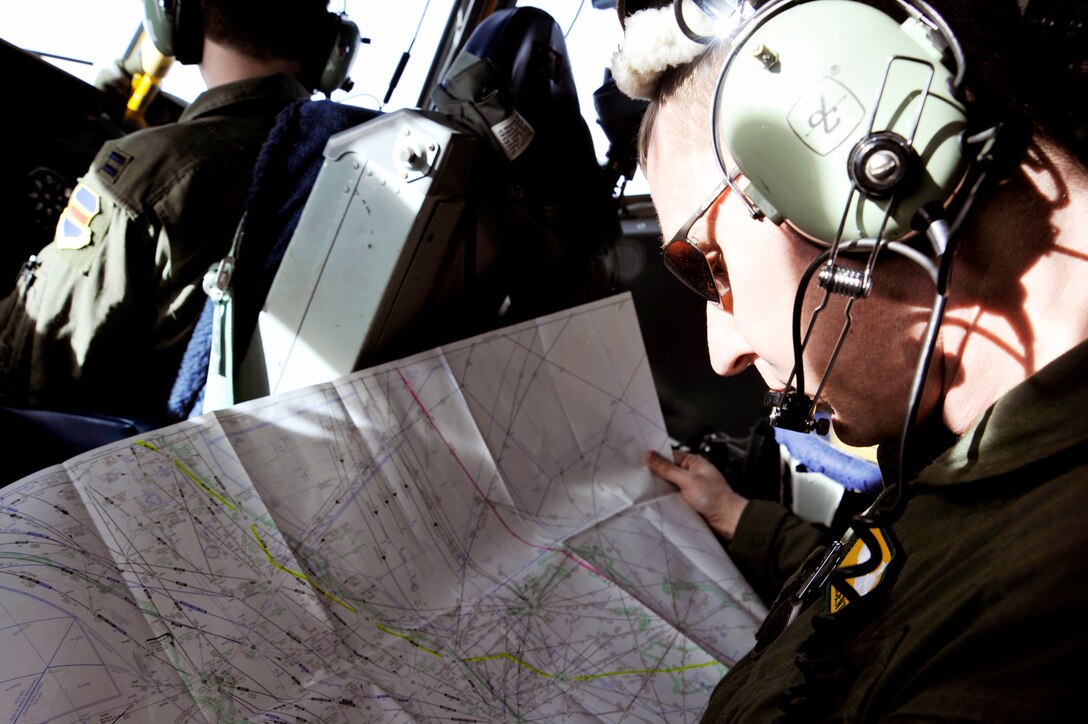 Maj. Vincent Zalesky checks navigational maps and provides another set of eyes for pilots flying the OC-135B Open Skies aircraft Jan. 16, 2010, over Haiti. Major Zalesky is a pilot with the 45th Reconnaissance Squadron at Offutt Air Force Base, Neb.  (U.S. Air Force photo/Airman 1st Class Perry Aston)